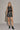 Black faux leather mini skirt with buckle waist detail styled with ankle boots — night-out look.