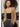 Model wearing the Mats Metallic Cardigan in a champagne gold metallic knit featuring an open-front design, long sleeves, lightweight shimmer fabric, and fitted silhouette layered over a black camisole and charcoal pants.