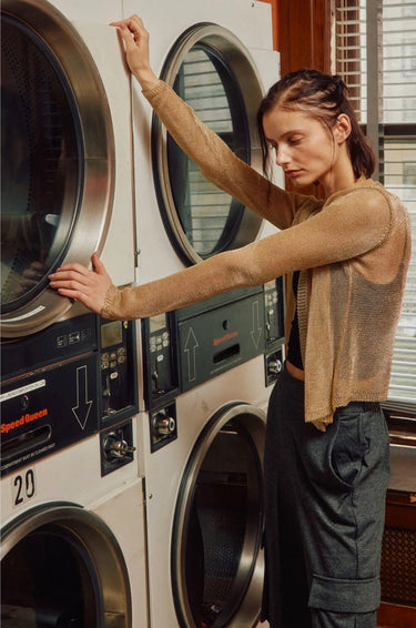 Lifestyle image of the Mats Metallic Cardigan featuring soft metallic knit fabric, long sleeves, and lightweight layering design styled with casual everyday attire.