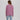 Person wearing a lavender colored sweater with a back design on a plain background