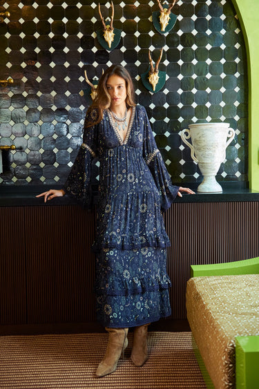 Model wearing Meli Maxi Dress in navy with metallic star print and long sleeves.