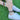Person wearing colorful bracelet and anklet on a grassy background