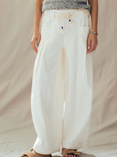 Mora wide-leg drawstring pants in ivory featuring oversized front patch pockets and a relaxed full-length silhouette.