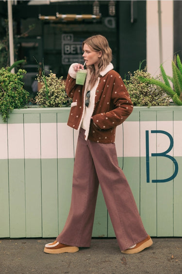 Model wearing the Oddet Pant in washed plum with a high-rise waist and relaxed full-length silhouette.