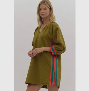Model wearing olive Krewer Dress with colorful side stripes and textured fabric.