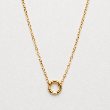 Orion gold-filled keeper charm necklace featuring a delicate gold chain and polished circular charm holder centered on a white textured background.