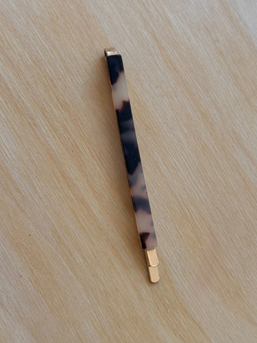 Rae Hair Clip — slim rectangular tortoiseshell hair clip with gold tip, minimalist hair accessory on neutral background.