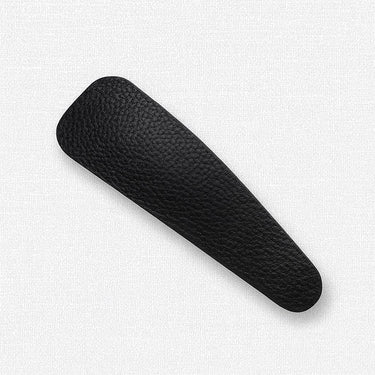 Raggedy Hair Clip in black eco-leather on white background, minimal accessory photo for Matte.