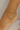 Close-up of a foot wearing a delicate silver anklet on a neutral background