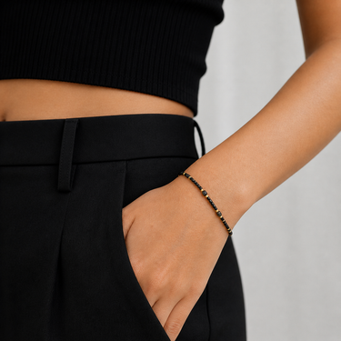 Remu Bracelet black beaded adjustable bracelet with gold accents worn on wrist with black outfit.