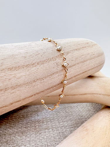 Gold Rhodes Bracelet with square pearl accents by Matte on wooden display