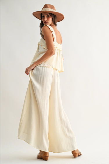Roblen Pant cream wide-leg trousers side view showing fluid drape and airy lightweight fabric movement.