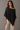 Rueth Poncho black lightweight poncho top with subtle shimmer, relaxed draped silhouette, and asymmetrical pointed hem for an elegant, flowing shape.