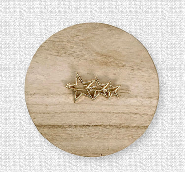Gold star-shaped hair clip with crystal accents on wood background – Sabina Hair Clip by Matte.