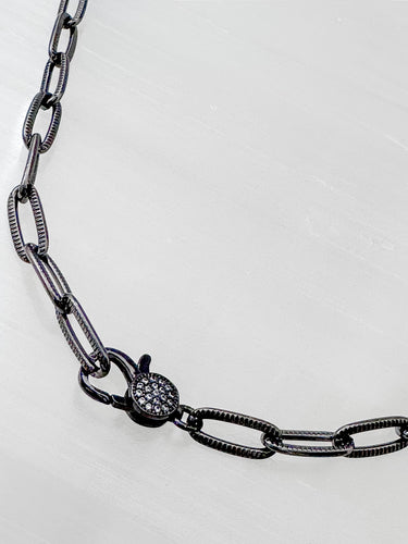 Seint necklace by Matte, black enamel chain with pavé clasp detail on light background