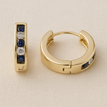Sera Huggie Earrings, gold huggie hoop earrings with round stone inlay detail and polished mirror finish, photographed on white linen background with soft editorial lighting.
