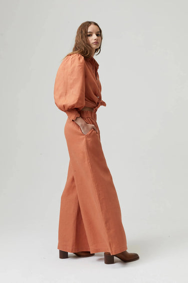 Model wearing Camille Blouse in terracotta organic linen with puff sleeves — Matte Concept Store