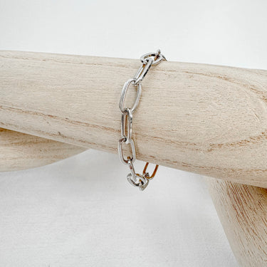 Silver link chain bracelet with rectangular oversized links displayed on wood stand - Matte Jewelry