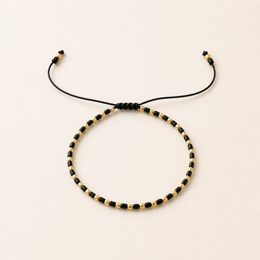 Solei Bracelet adjustable black and gold beaded bracelet with sliding cord closure.