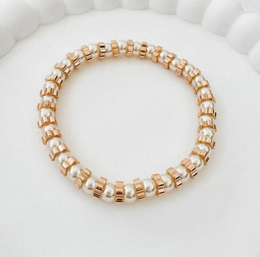 Stelle gold and pearl stretch bracelet displayed on white surface