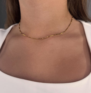 Model wearing Teresina Necklace by Matte, gold filled tube chain, minimalist choker