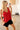 Model wearing the Terra Top in red — silk V-neck tank, relaxed fit, paired with black shorts, minimalist resort look.