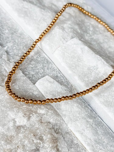 Tight Necklace by Matte, gold filled ball chain choker on white marble surface