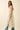 Tiks Layering Midi Dress ivory bohemian midi layered over denim jeans styled for editorial modern look, side view.