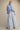 Model wearing Tjar blue striped high-rise wide-leg pants with statement top.