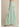 Side view of green and white striped wide-leg pants showing the fluid drape and relaxed fit.