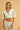 Model wearing the Tottem Crop Top in white — cotton eyelet fabric, cropped silhouette, V-neck, wide sleeves, close up.