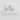 Polished silver teardrop Trena stud earrings resting on a white stone against a neutral fabric background.