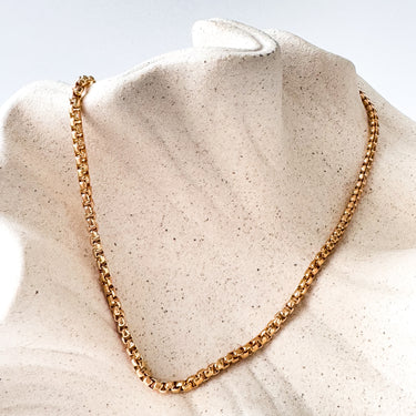 Gold chain necklace against a light background