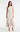 Model wearing the Vania Dress with cascading ruffles and a sculptural gold-tone buckle.