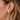 Vire Stud Earrings worn on ear showing sculptural gold-tone stud design.