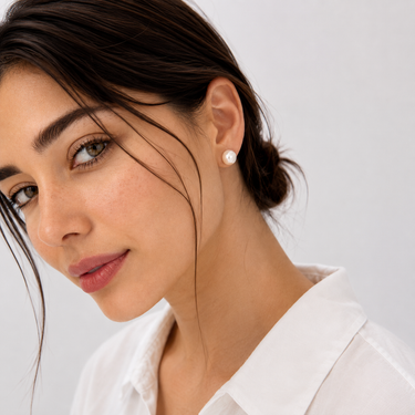 Model wearing the Wak Stud Earrings featuring luminous freshwater button pearls with a softly rounded shape, styled on the earlobe to showcase their timeless everyday elegance.