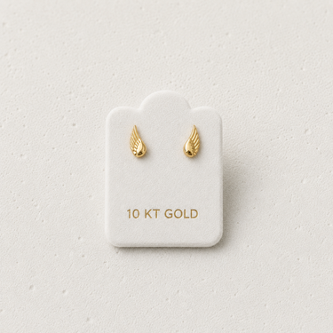 Wings Mini Stud Earrings featuring genuine 10K gold wing-shaped stud earrings displayed on a jewelry card against a light neutral background, showcasing their delicate minimalist design for everyday wear.