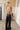 Woman wearing black and gold sequin halter jumpsuit — luxury evening outfit, back view