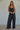 Zia Top relaxed draped black camisole with spaghetti straps styled with wide-leg pants.