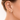 Huggie Hoop Earrings Collection – close-up of a woman’s ear styled with multiple gold huggie hoops in different sizes, including a pavé huggie and a delicate gold ear cuff, photographed in soft natural light with a neutral background.
