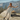 Matte Loved By You Collection image featuring a model wearing a flowing cream lace maxi dress styled with black boots, set against a sunlit desert landscape with mountains in the background.