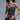  Matte Bodysuit Collection – model wearing black embellished corset bodysuit with rhinestone details, layered silver necklaces, and black denim jeans
