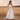 Matte All Bottoms collection image – model wearing a white cropped tank top with a flowing white maxi skirt in a golden sunset field