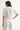 Woman wearing a white blouse and pants against a white background
