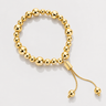 Aka Bracelet gold beaded bracelet with polished mirror finish beads and adjustable slider closure on neutral background
