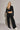 Woman wearing black Akima cropped velvet jacket with matching pants, full look front view.