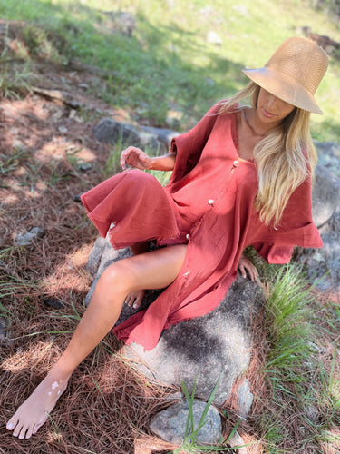 Alba Cover Up coral resort cover up dress flowing fabric detail while sitting on rocks in nature