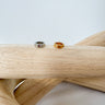 Two ear cuffs, one silver and one gold, displayed on a wooden surface.