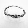Alrea Stretch Bracelet with metallic beads and crystal centerpiece on white stone background – Matte Jewelry