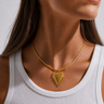 Amaita Necklace gold textured heart pendant necklace worn on model showing bold statement pendant and delicate cord chain.